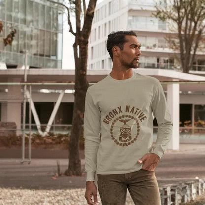 Man wearing a 'Bronx Native' sweatshirt standing outdoors with modern buildings in the background